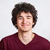 Portrait of a smiling young man with curly dark hair